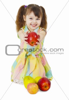 Happily smiling little girl gives an apple
