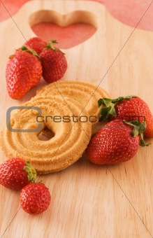 Fresh strawberries with cookies on wooden board