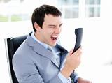Furious young businessman yelling on phone