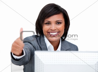 Cheerful businesswoman with a thumb up working at a computer