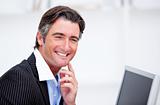 Smiling businessman working at a computer 