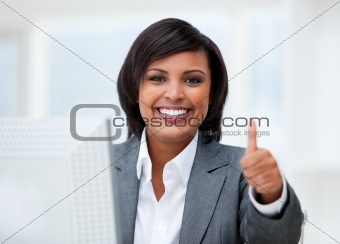 Happy businesswoman with a thumb up working at a computer