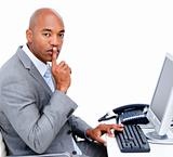 Confident businessman asking for silence sitting at his desk 