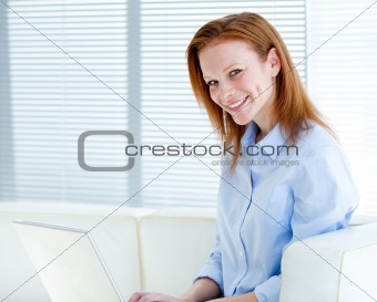 Smiling business woman working on a laptop computer 