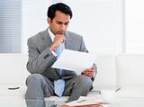 Confident businessman reading a note 