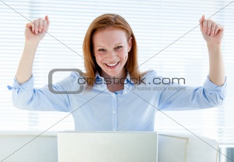 Bright business woman punching the air