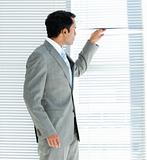 Confident businessman looking through a window