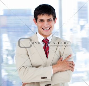 Smiling businessman with folded arms standing