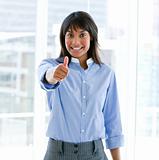 Cheerful female executive with a thumb up standing