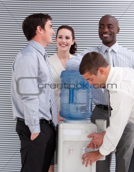 Smiling multi-ethnic business people interacting at a watercoole