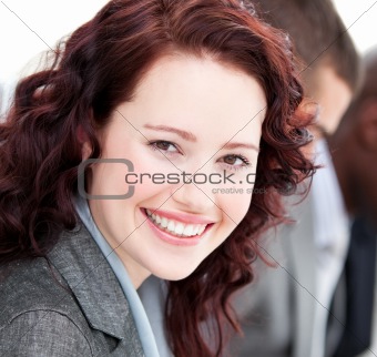 Close-up of a buinesswoman smiling at the camera in a meeting