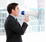 Frustrated businessman yelling through a megaphone 