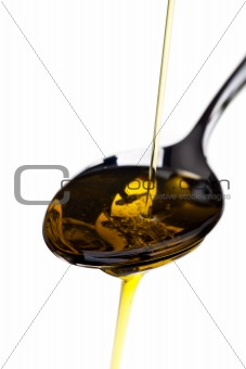 oilve oil being poured over a spoon