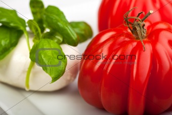 tomatoes, mozzarella and basil while making insalada caprese