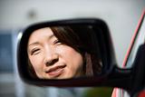 Smiling woman in car mirror