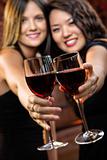 Women toasting wine glasses