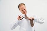 Businessman cutting necktie
