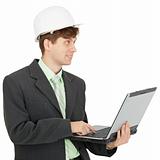 Smiling engineer in helmet with laptop in hands