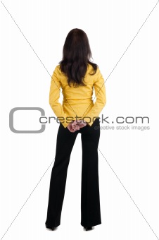 Young woman in yellow suit looking at wall.