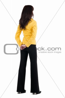 Young woman in yellow suit looking at wall. 
