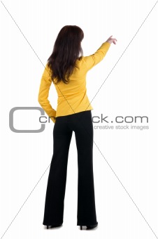 Young woman points at wall.