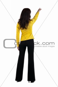 Young woman points at wall. The rear view