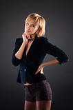 sexual blond woman in short skirt . Black background.