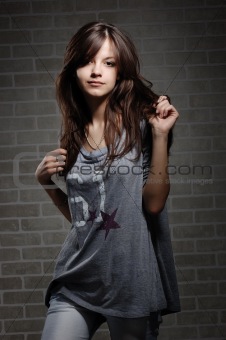 womanly brunette on brick wall background . 