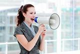 Self-assured businesswoman yelling through a megaphone