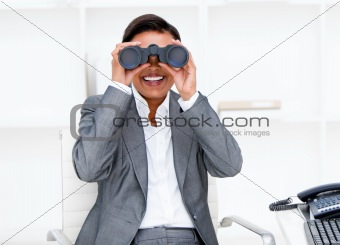 Jolly businesswoman looking through binoculars 