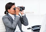 Self-assured businesswoman looking through binoculars