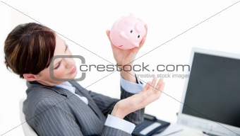 Upset businesswoman holding a piggy-bank 