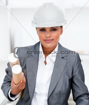 Confident female architect holding blueprints