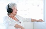 Senior woman listening music with headphones 
