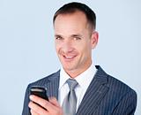Confident businessman sending a text with his  phone 