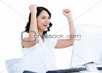 Positive  businesswoman punching the air in front of her compute