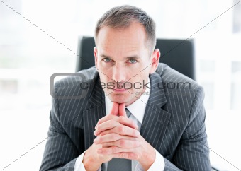 Serious businessman looking at the camera sitting 
