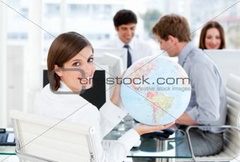 Confident businesswoman holding a globe