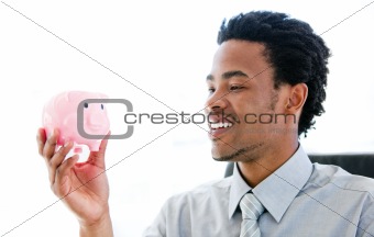 Nice afro-american businessman holding a piggybank