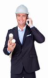 Smiling businessman on phone and holding blueprints