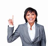 Businesswoman pointing upwards smiling at the camera 