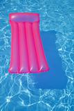 Pink air bed floating on a swimming pool