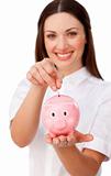 Happy young businesswoman saving money in a piggybank 