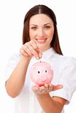 Young brunette businesswoman saving money in a piggybank 