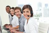 Happy co-workers with headsets on working in call center