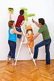 Happy family redecorating the house - painting