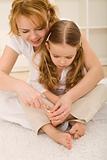 Personal grooming - woman and little girl cutting toe nails