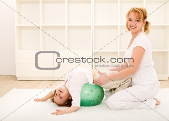 Happy woman and kid making gym exercises