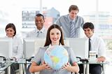 Brunette businesswoman and her team showing a terrestrial globe