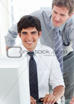 Handsome businessman working at a computer with his manager